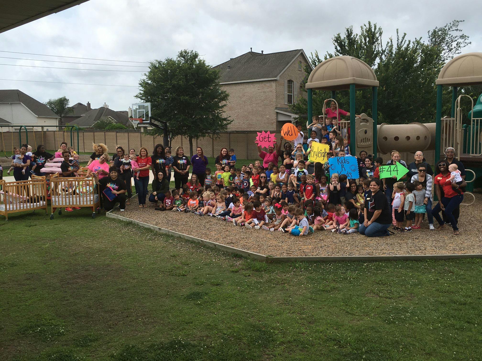 Large group of adults and children gathered on a playground