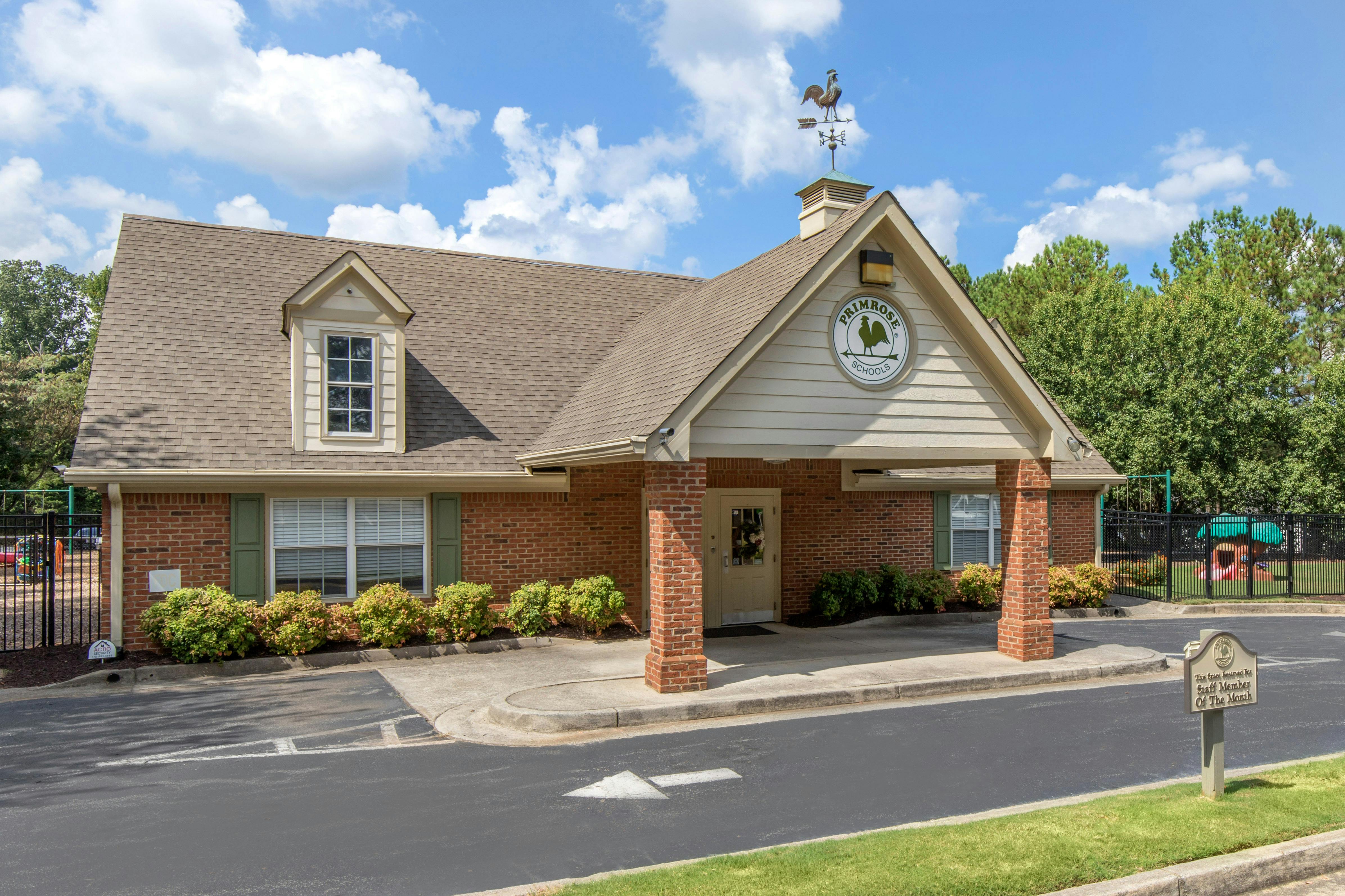 Brick building with a roof sign that says Primrose Schools and a rooster weathervane