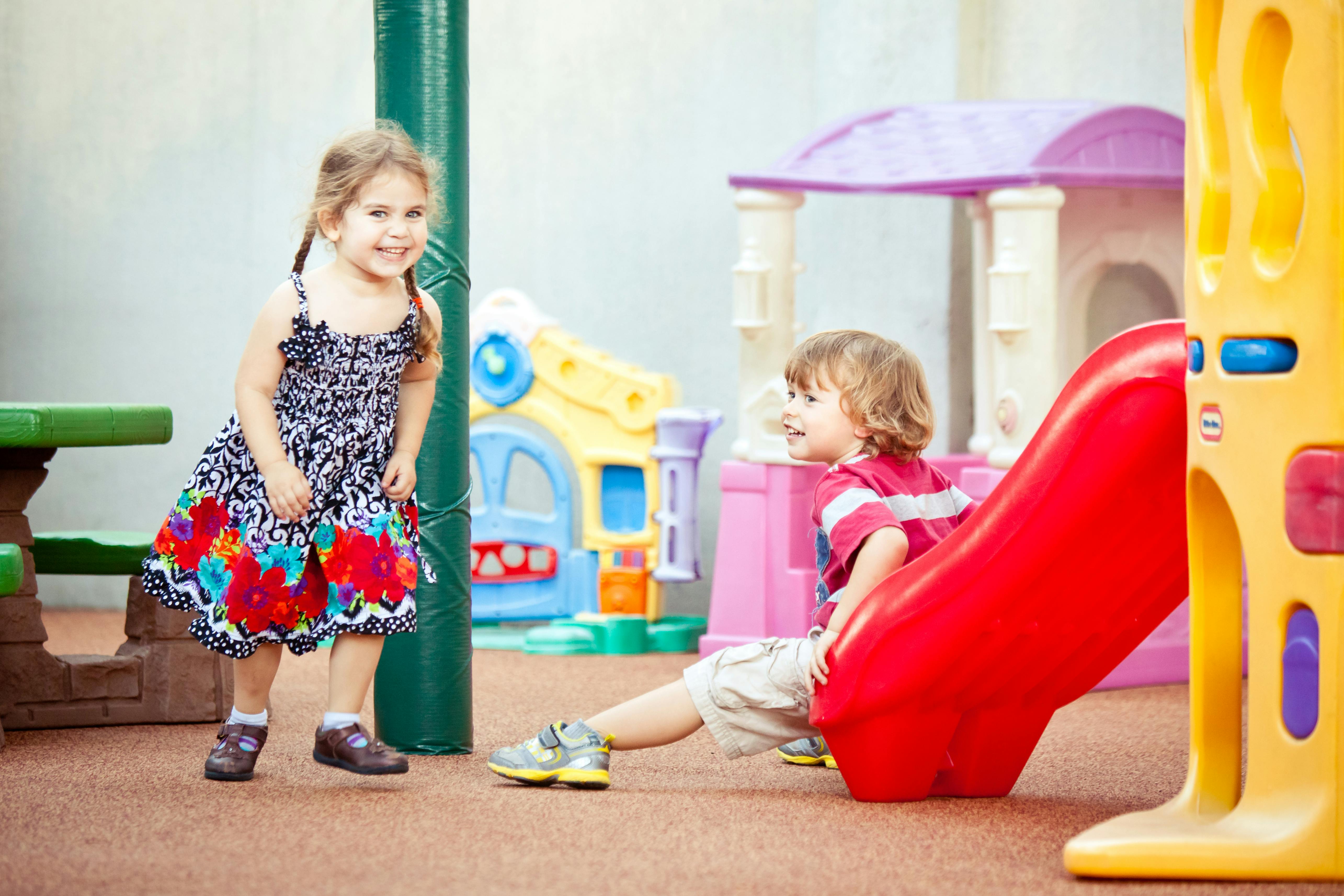 Two children playing on a playground slide