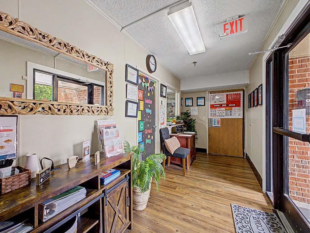 Entrance area of a building with a counter, a mirror, and an exit sign