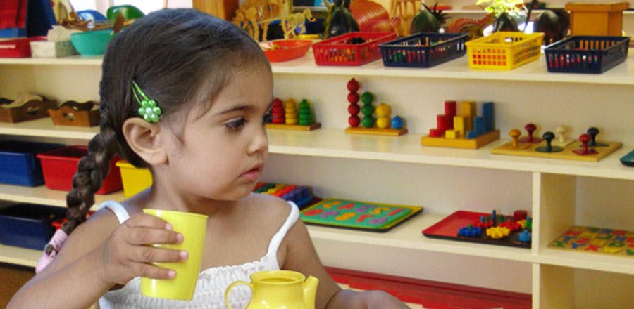 Child holding a cup in a classroom
