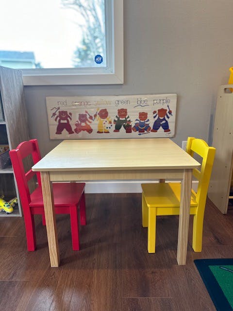 Children's table with a red chair and a yellow chair