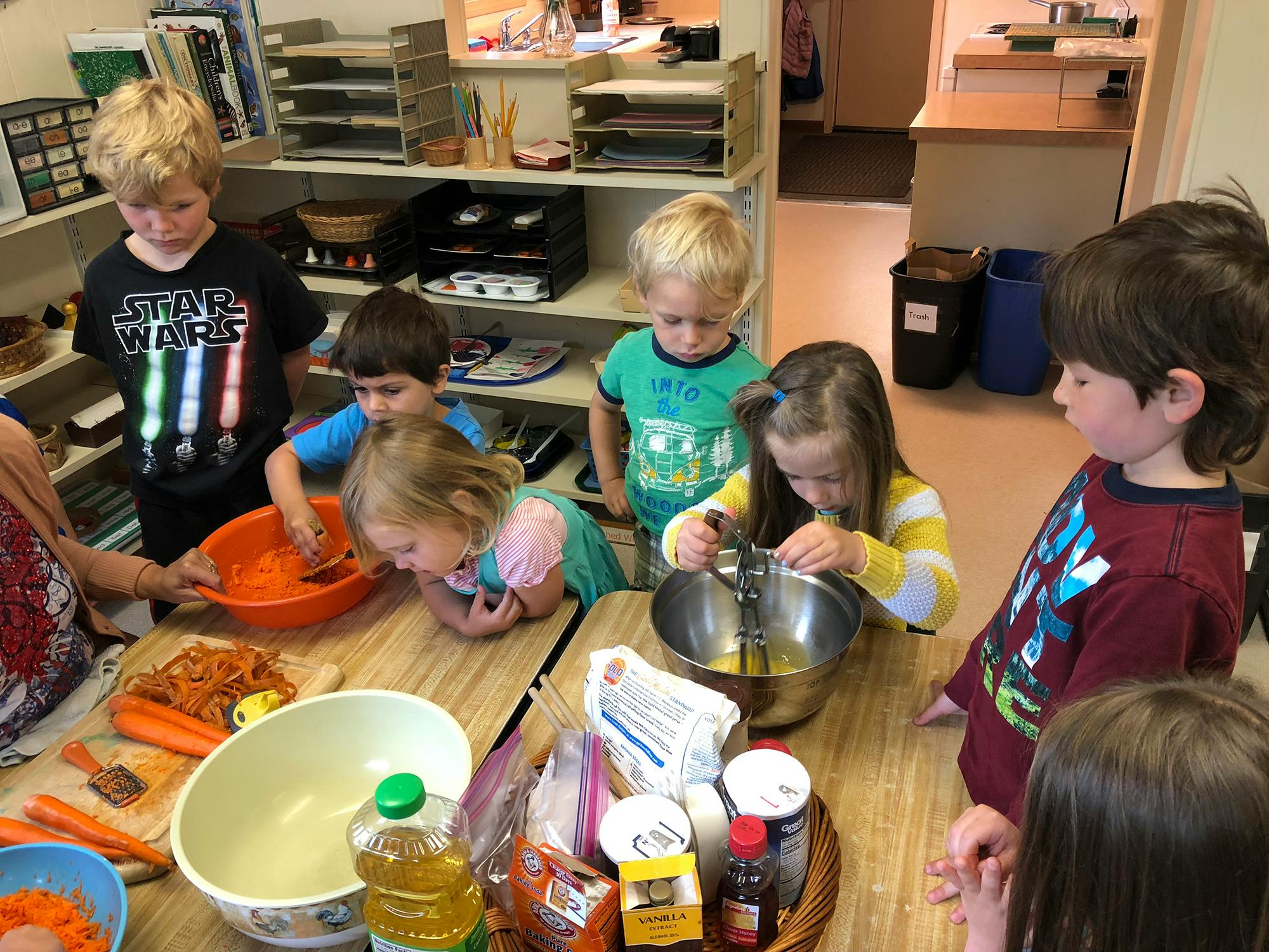 Children gathered around a table preparing food