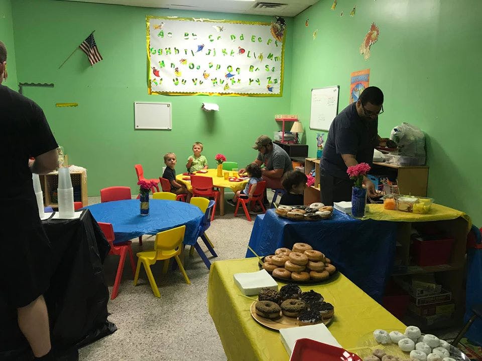 People and children in a room with tables of food
