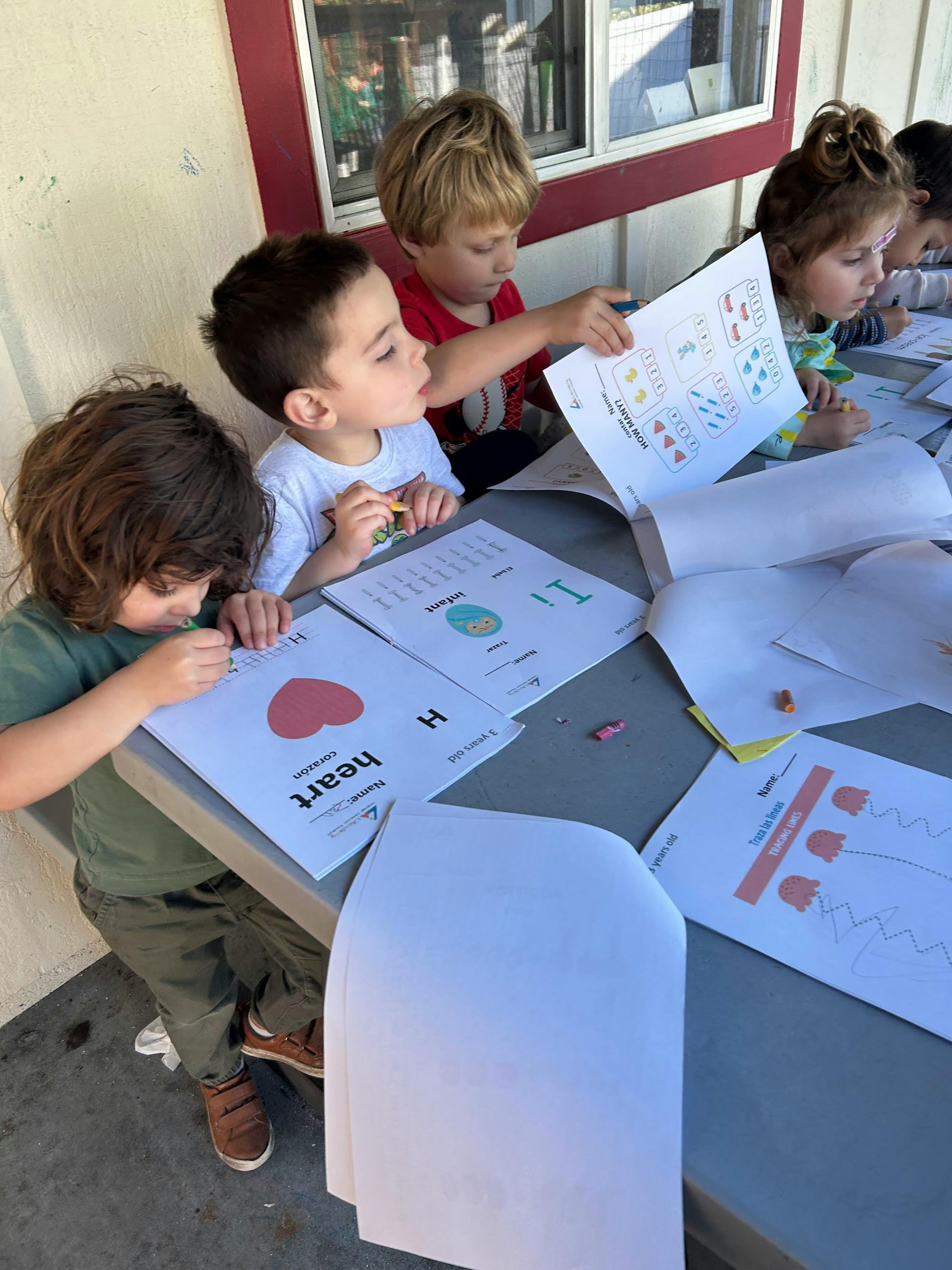 Children working on educational worksheets at a table