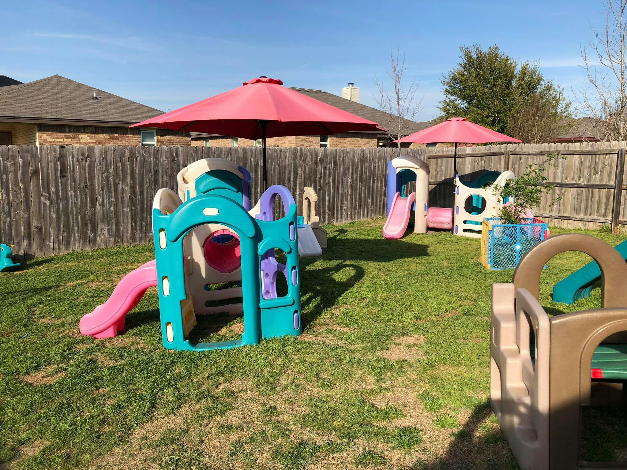 Outdoor playground with multiple colorful plastic play structures and slides