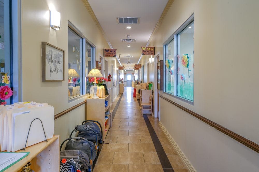 Long hallway with windows on both sides and backpacks on the floor