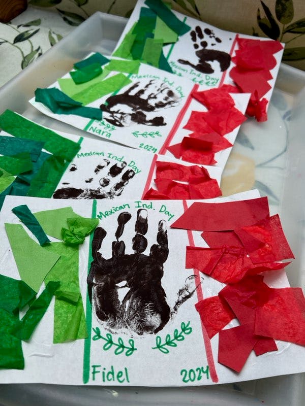 Children's artwork with handprints and green and red paper