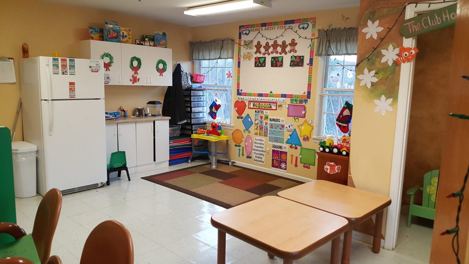 Classroom with white cabinets, refrigerator, and small tables