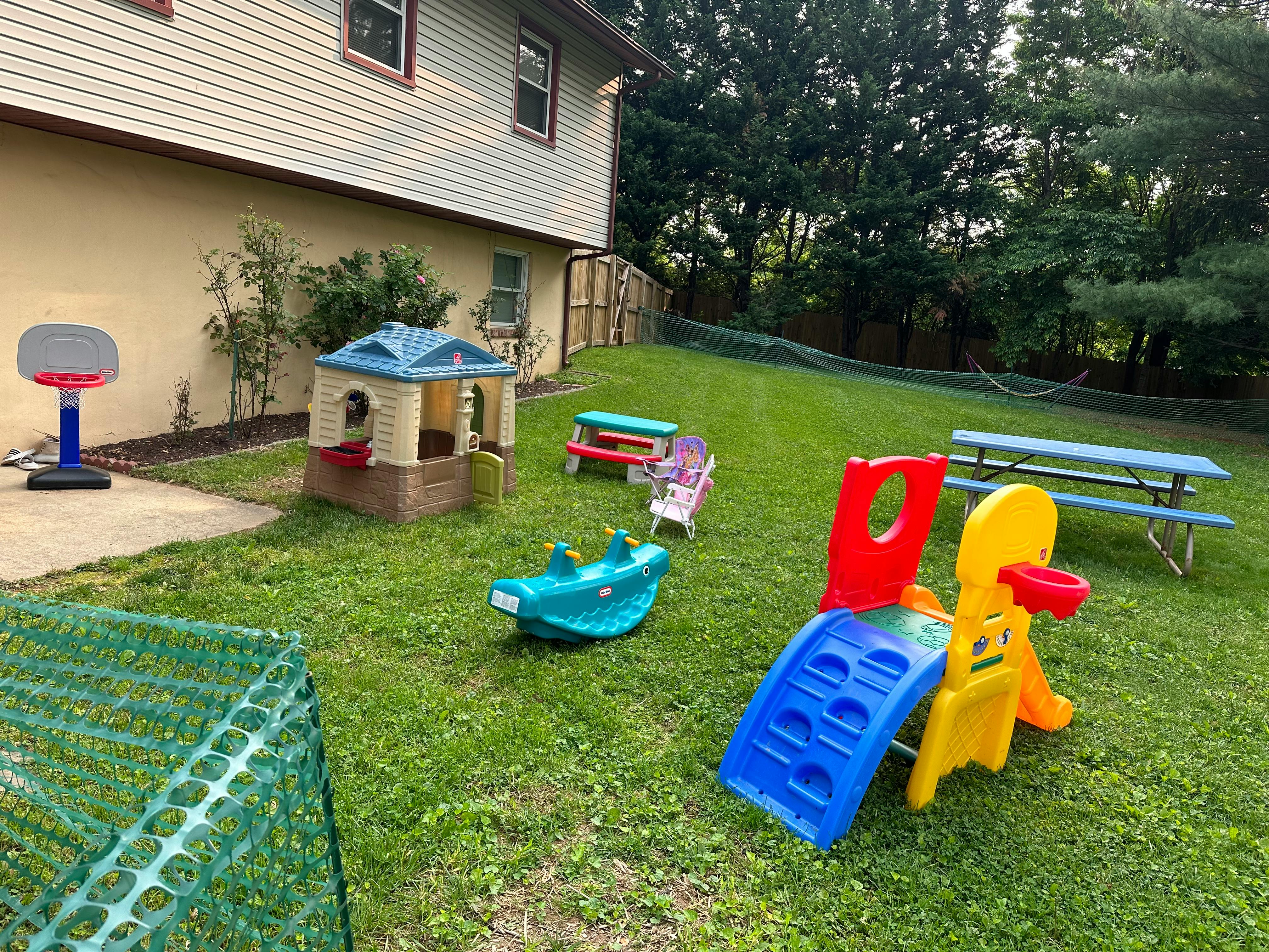 Outdoor play area with various toys and a small house