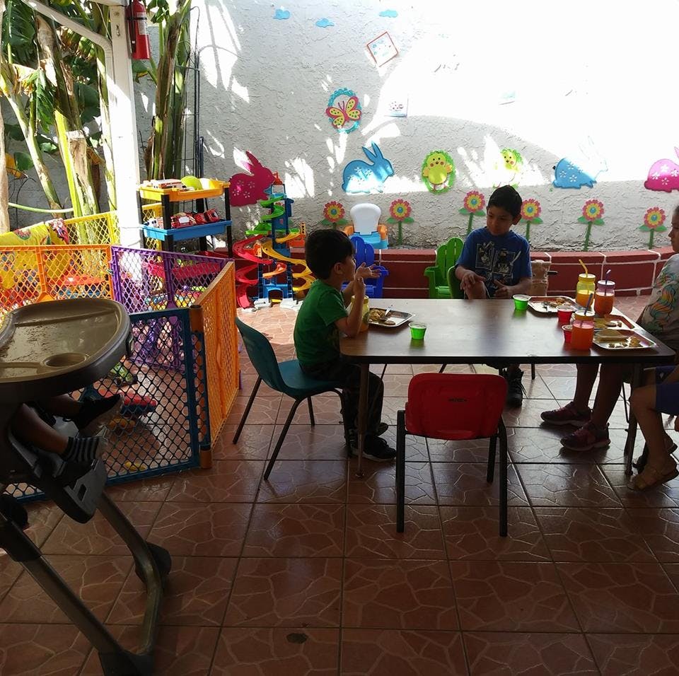 Children eating at a table in a play area