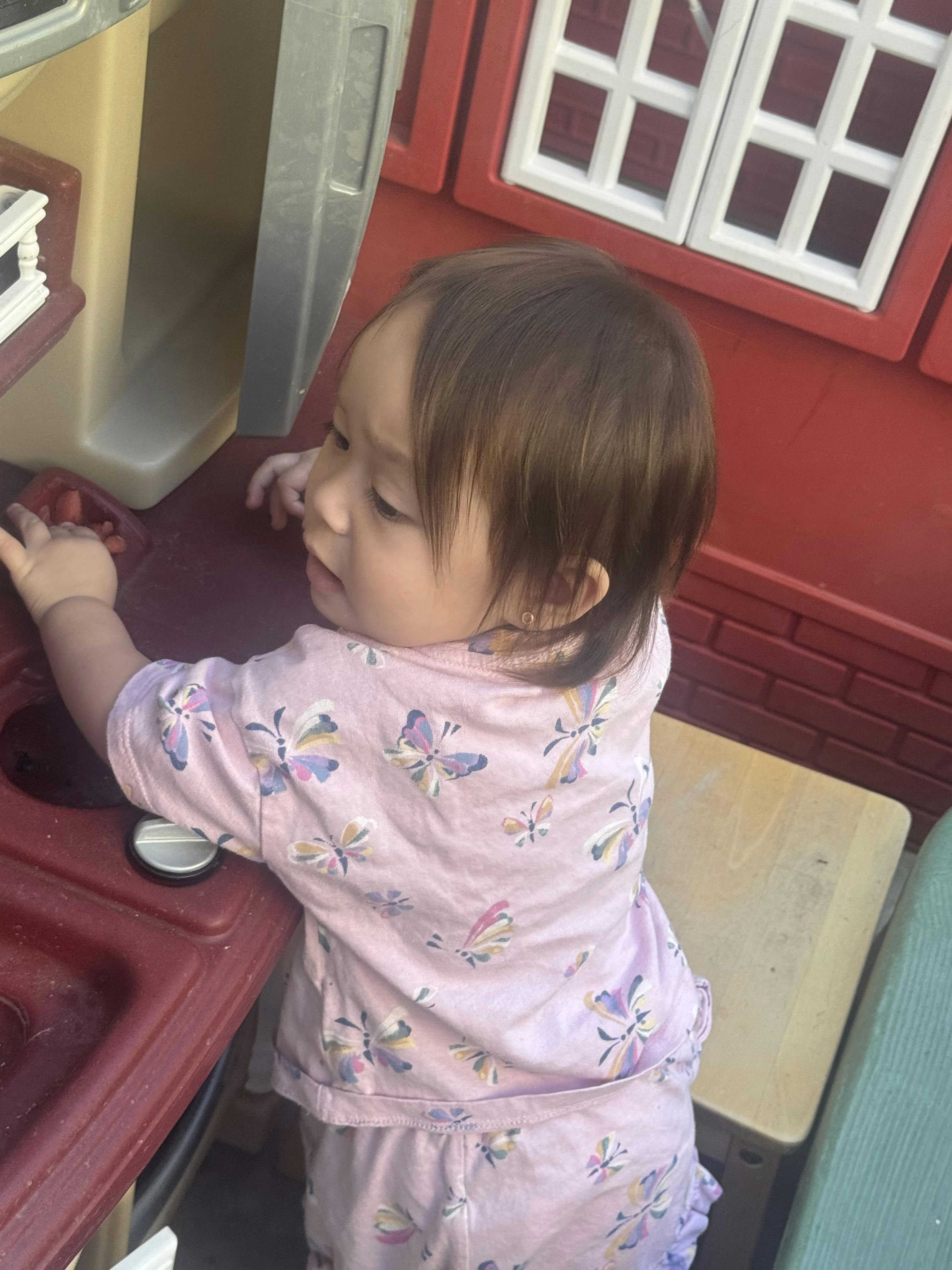 Child playing with a toy kitchen playset