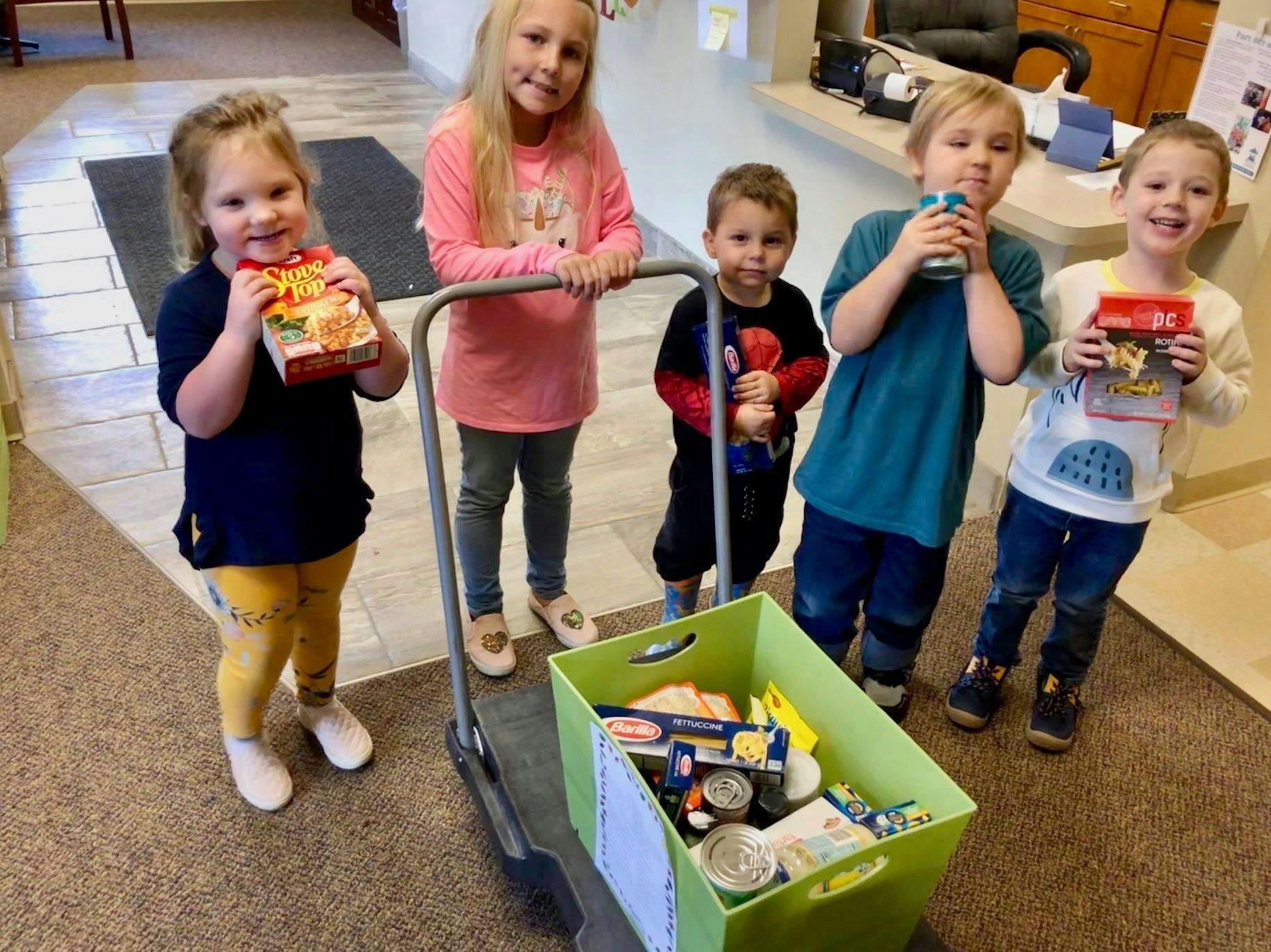 Five children with a cart full of food donations