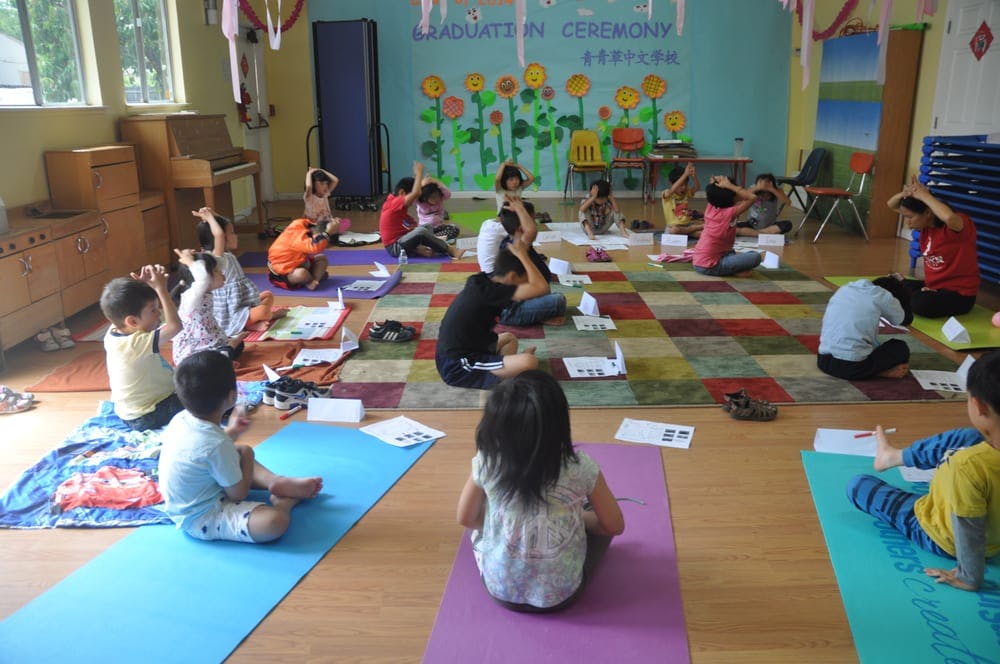 Children sitting on yoga mats in a classroom