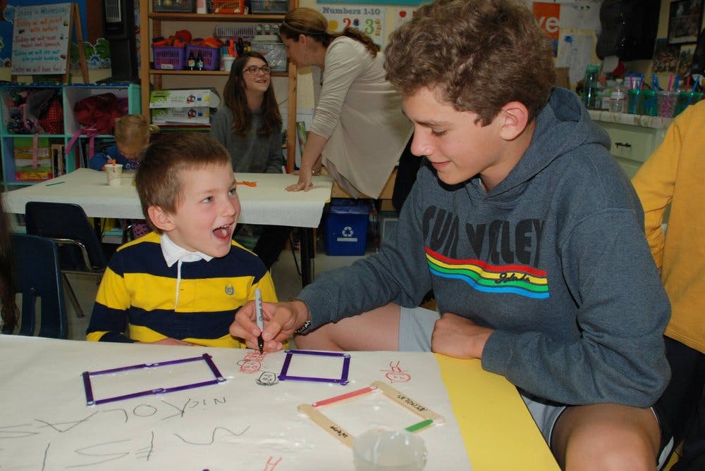 Teen and child drawing at a table