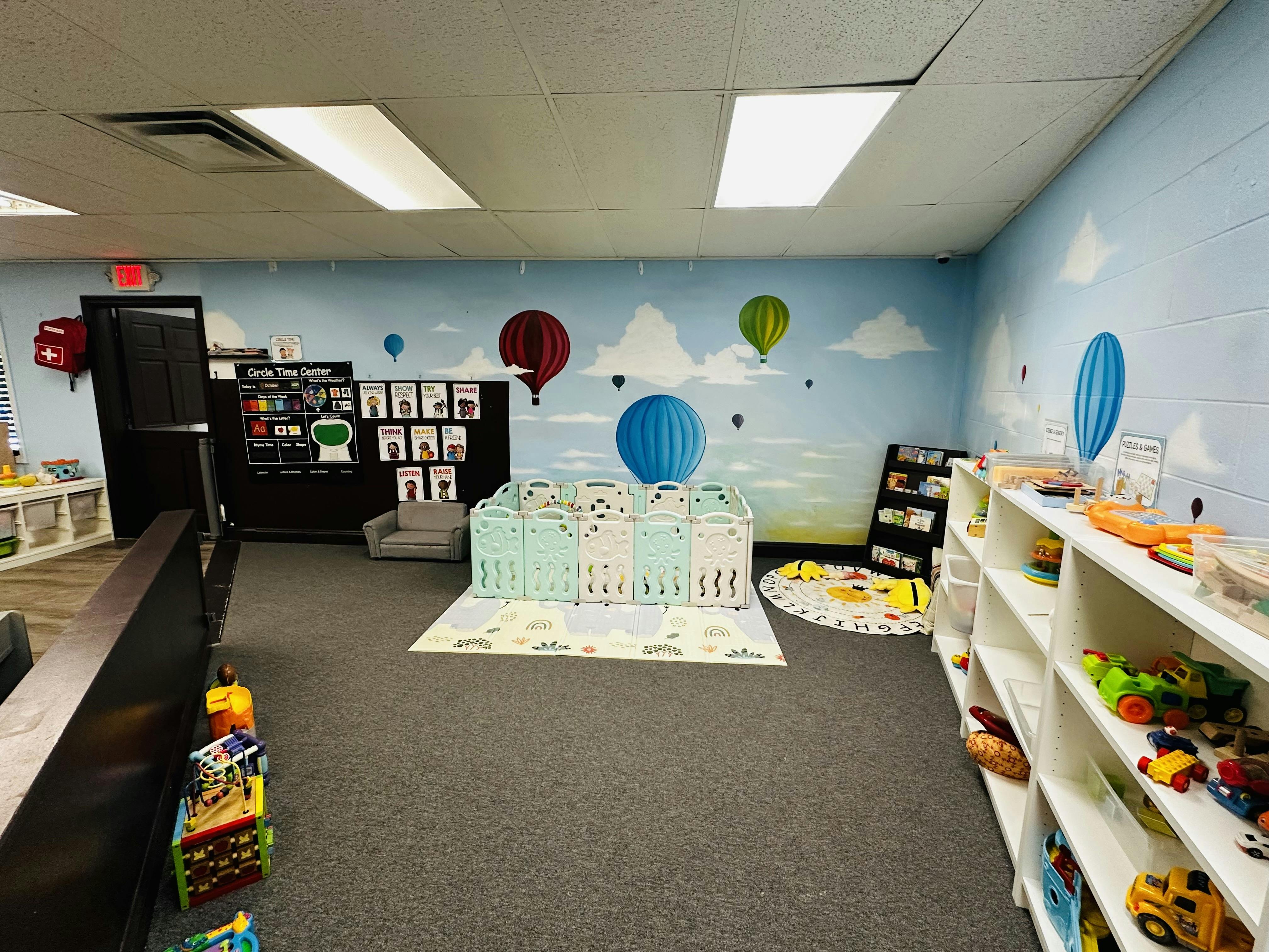 Playroom with hot air balloon mural, playpen, and shelves of toys