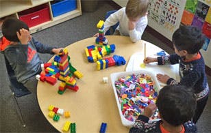 Children playing with blocks and drawing at a table