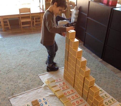 Child building a tower with wooden blocks