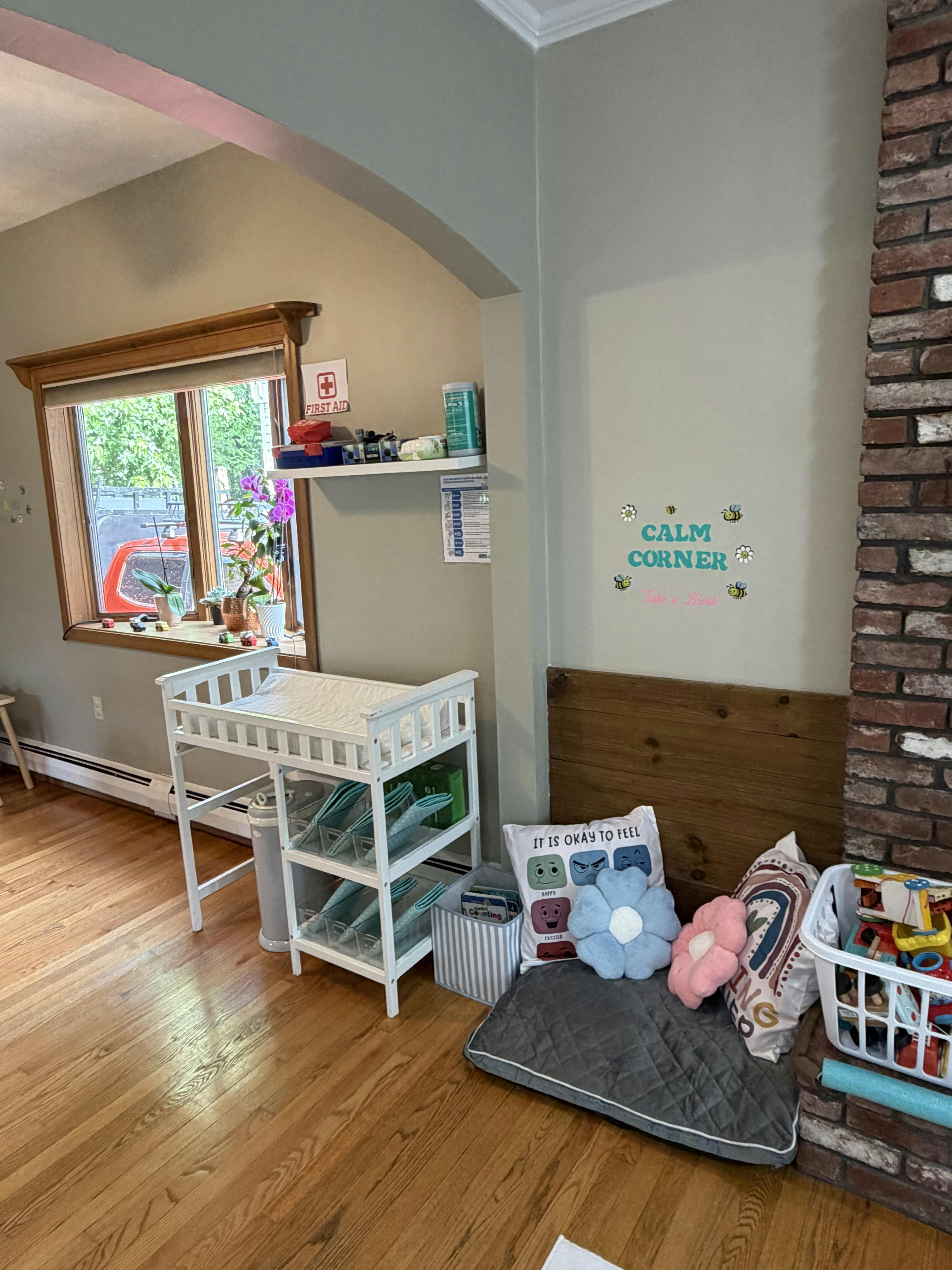 Calm corner with pillows and a mat next to a baby changing table