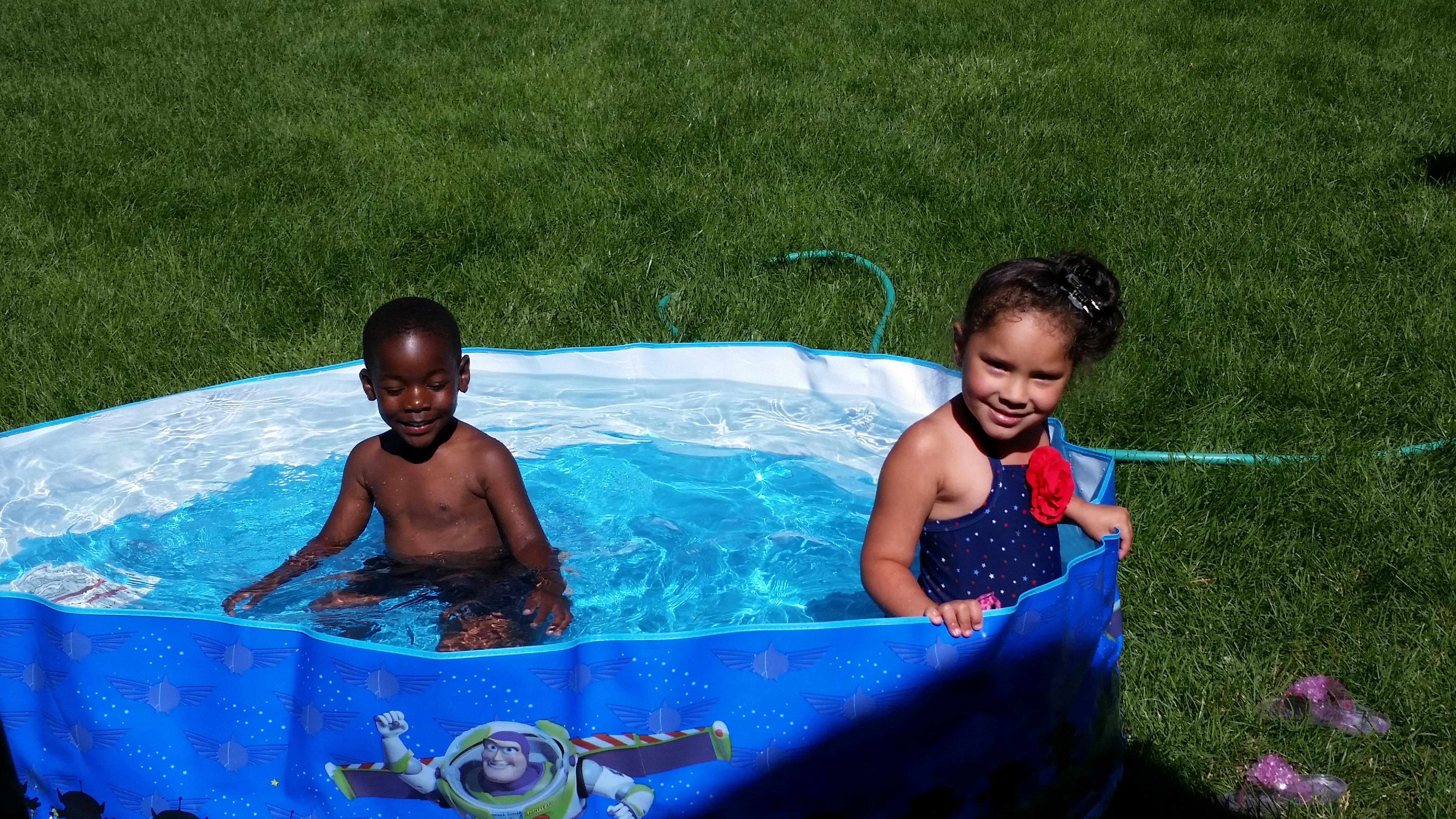 Two children in a small inflatable pool