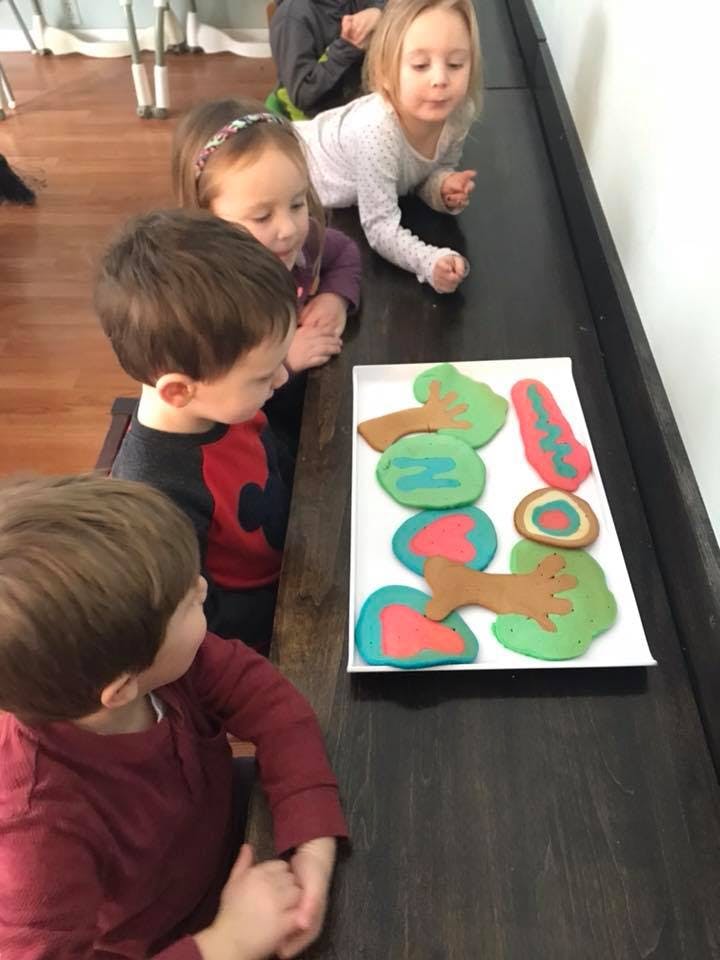 Children looking at a tray of colorful pancakes