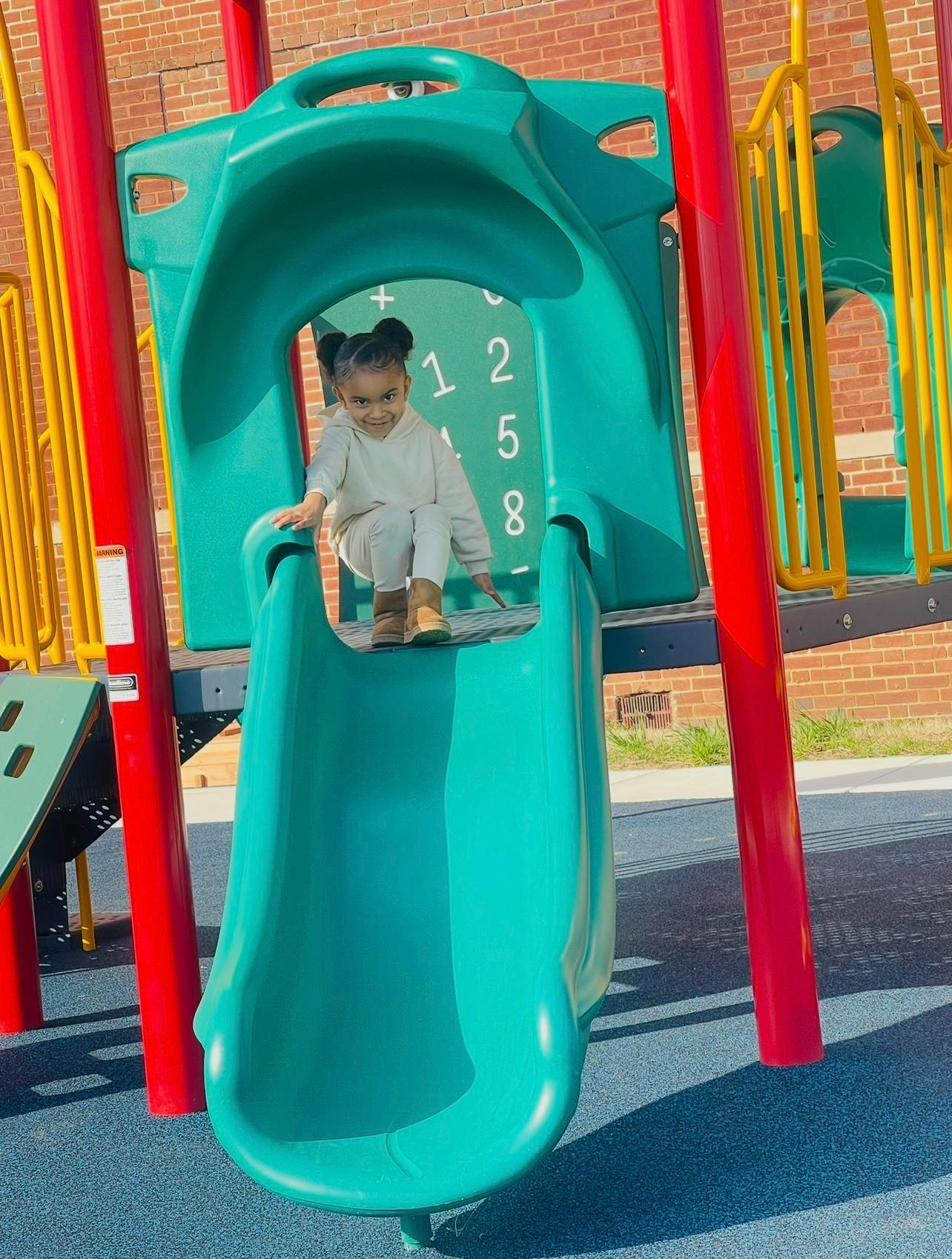 Child sitting on a playground slide