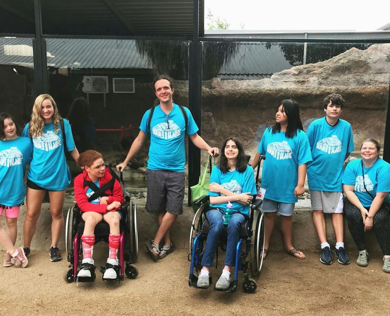 Group of people, including two in wheelchairs, posing outdoors