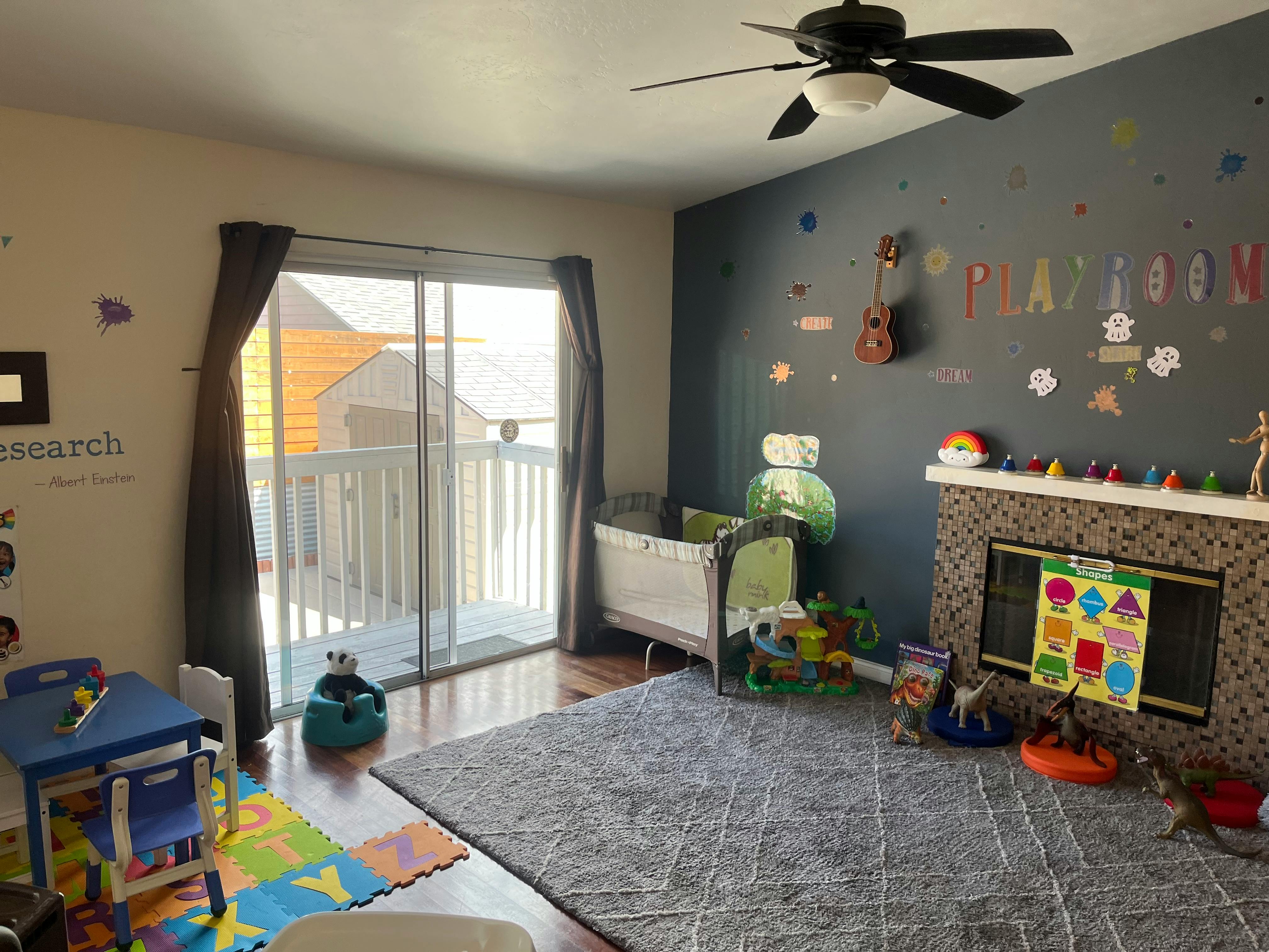 Child's playroom with crib, toys, and sliding glass door to balcony