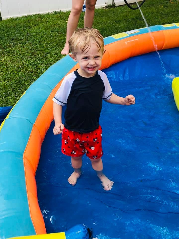 Child standing in an inflatable pool