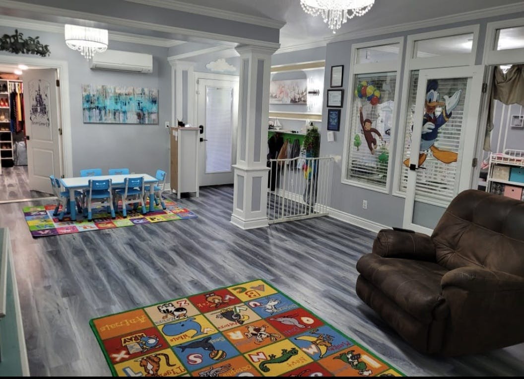 Playroom with small blue table and chairs, colorful rugs, and a brown armchair