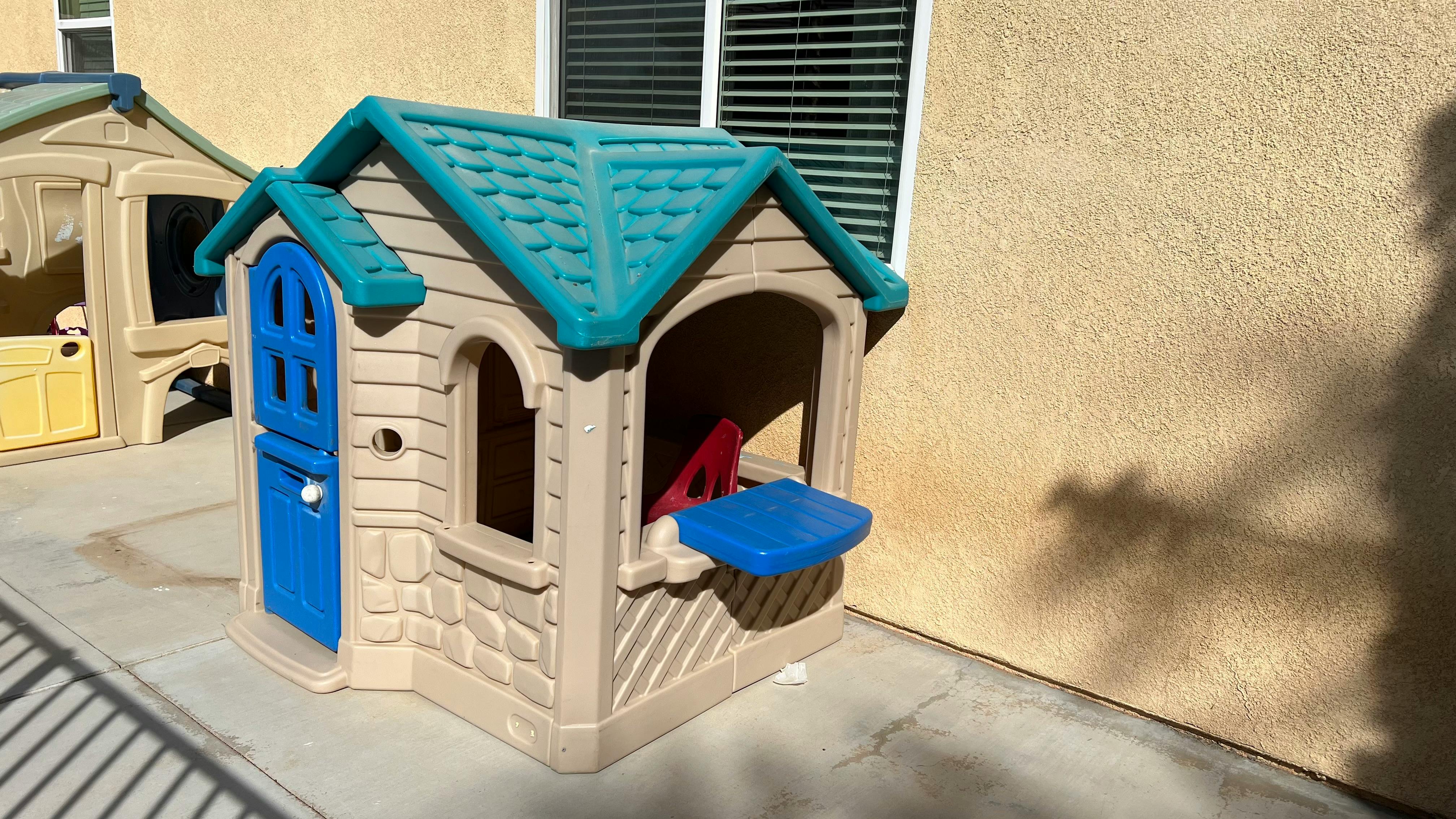 Plastic playhouse with blue door and roof