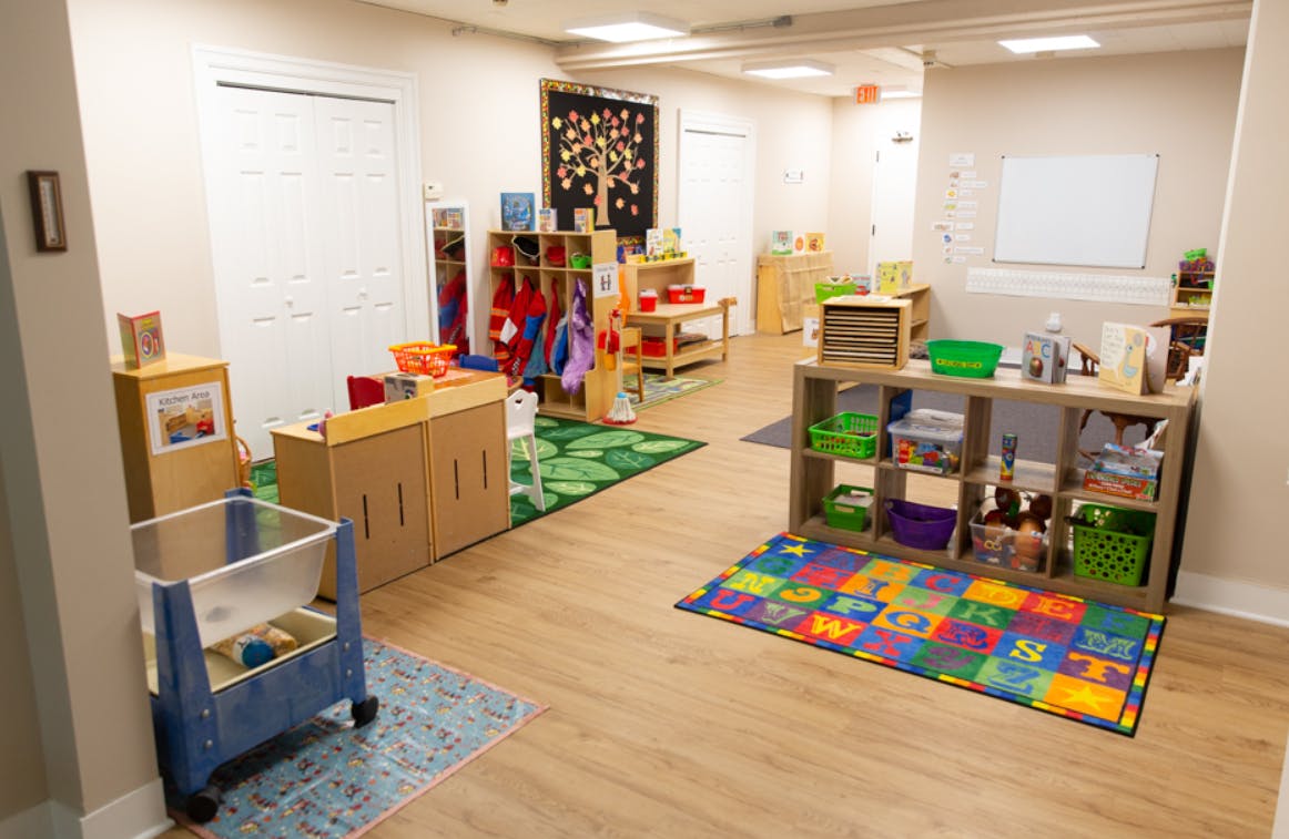 Classroom with various shelves, rugs, and learning materials