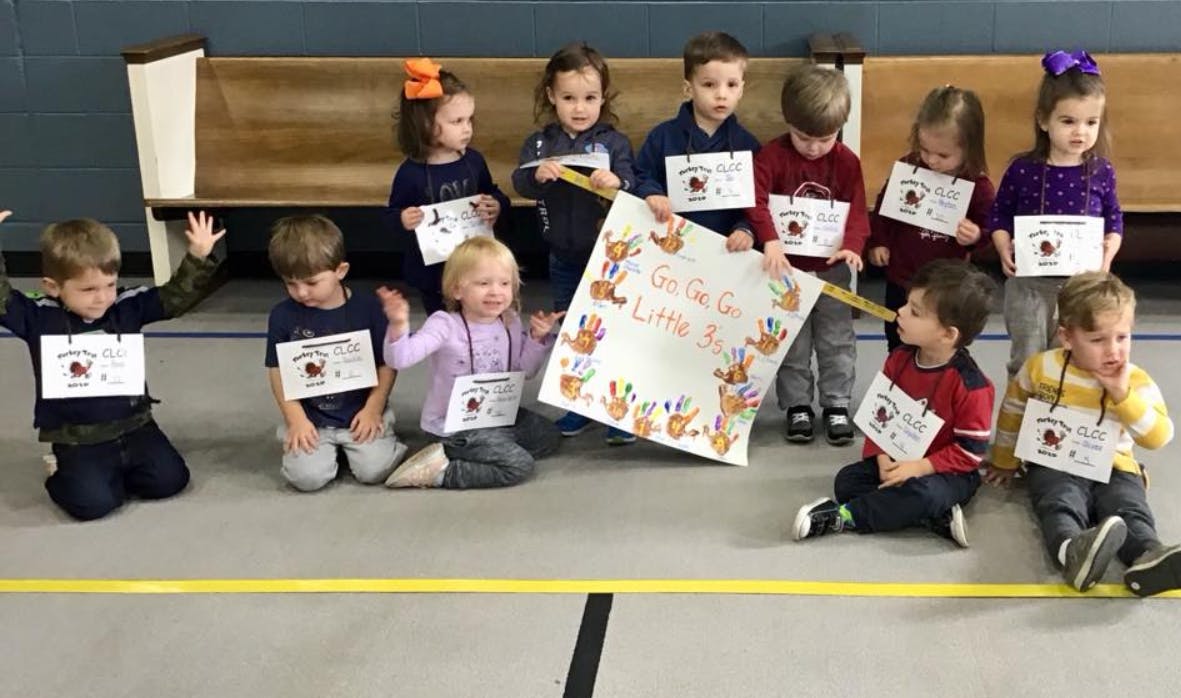 Group of children holding signs and a banner