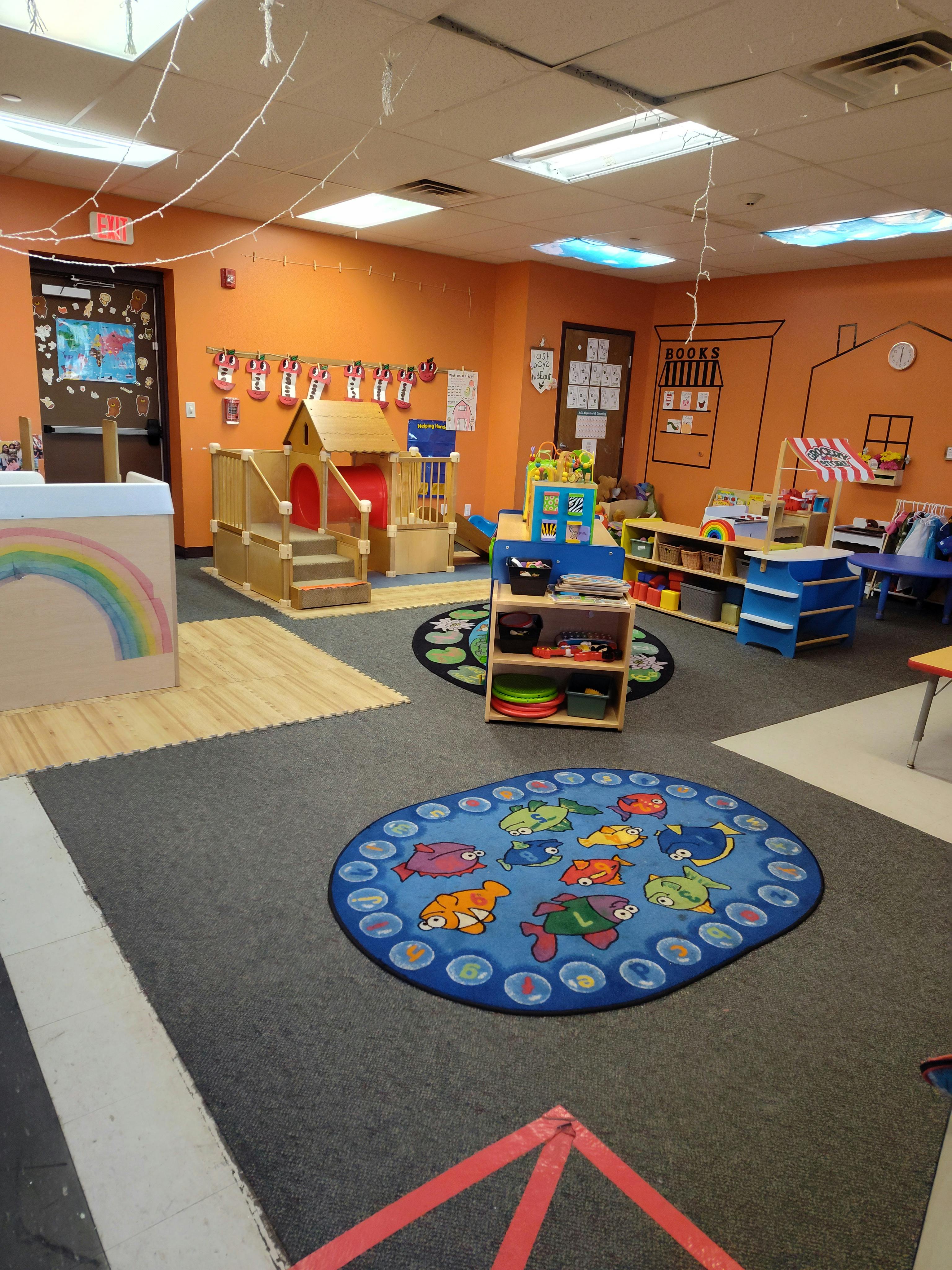 Playroom with a small indoor play structure and colorful rugs