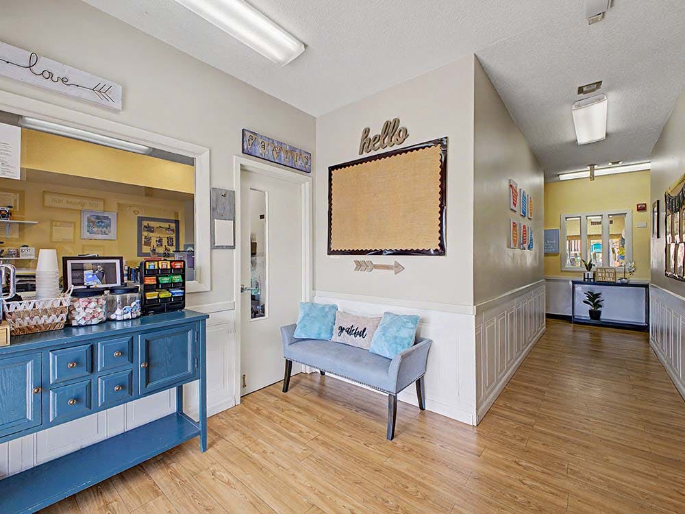 Lobby area with a blue cabinet, bench, and bulletin board