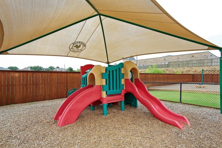 Playground structure with slides under a shade canopy