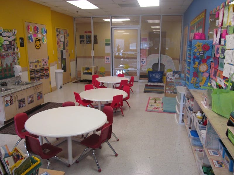 Classroom with small round tables and red chairs