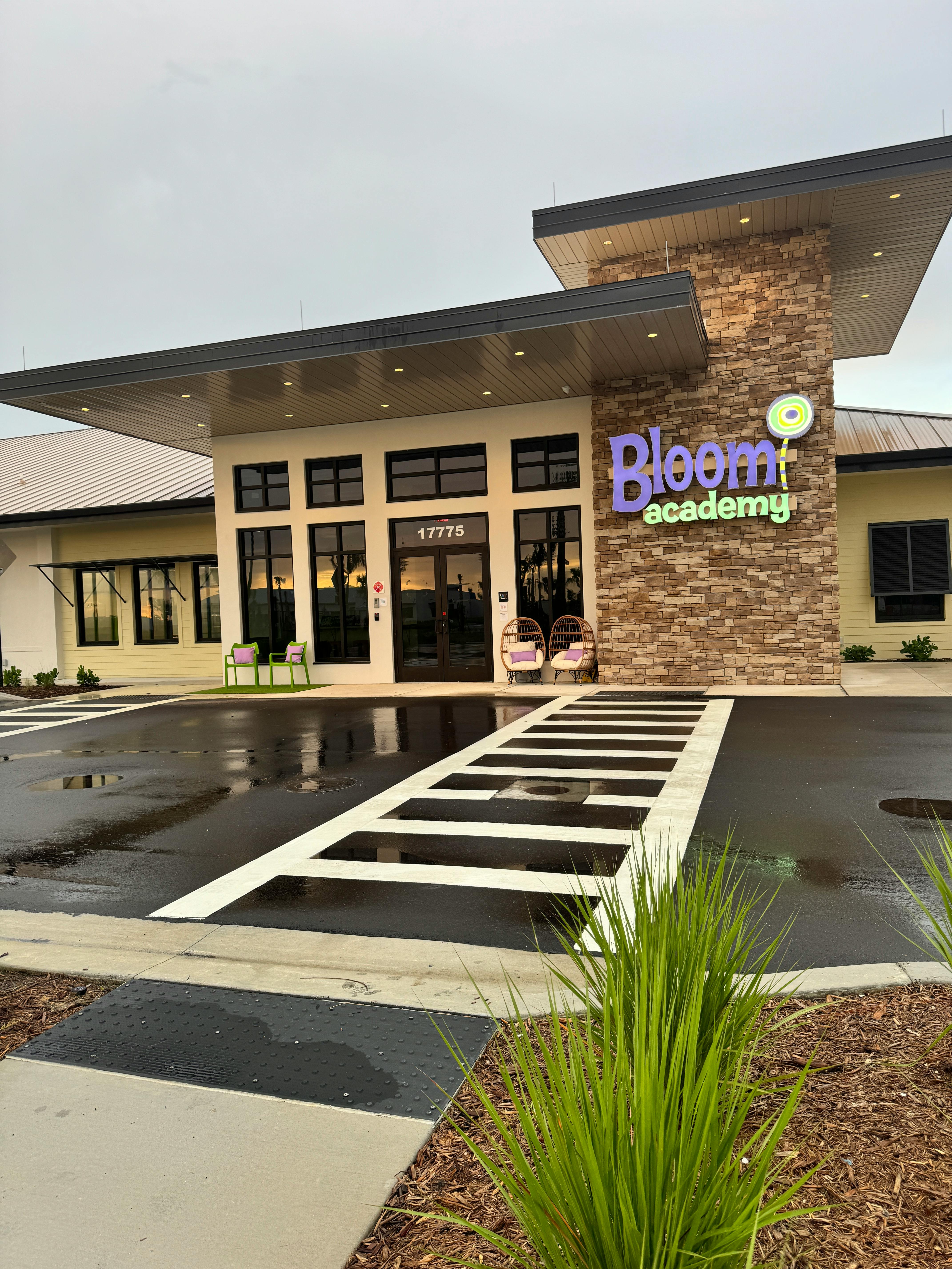 Building with "Bloom Academy" sign and striped crosswalk