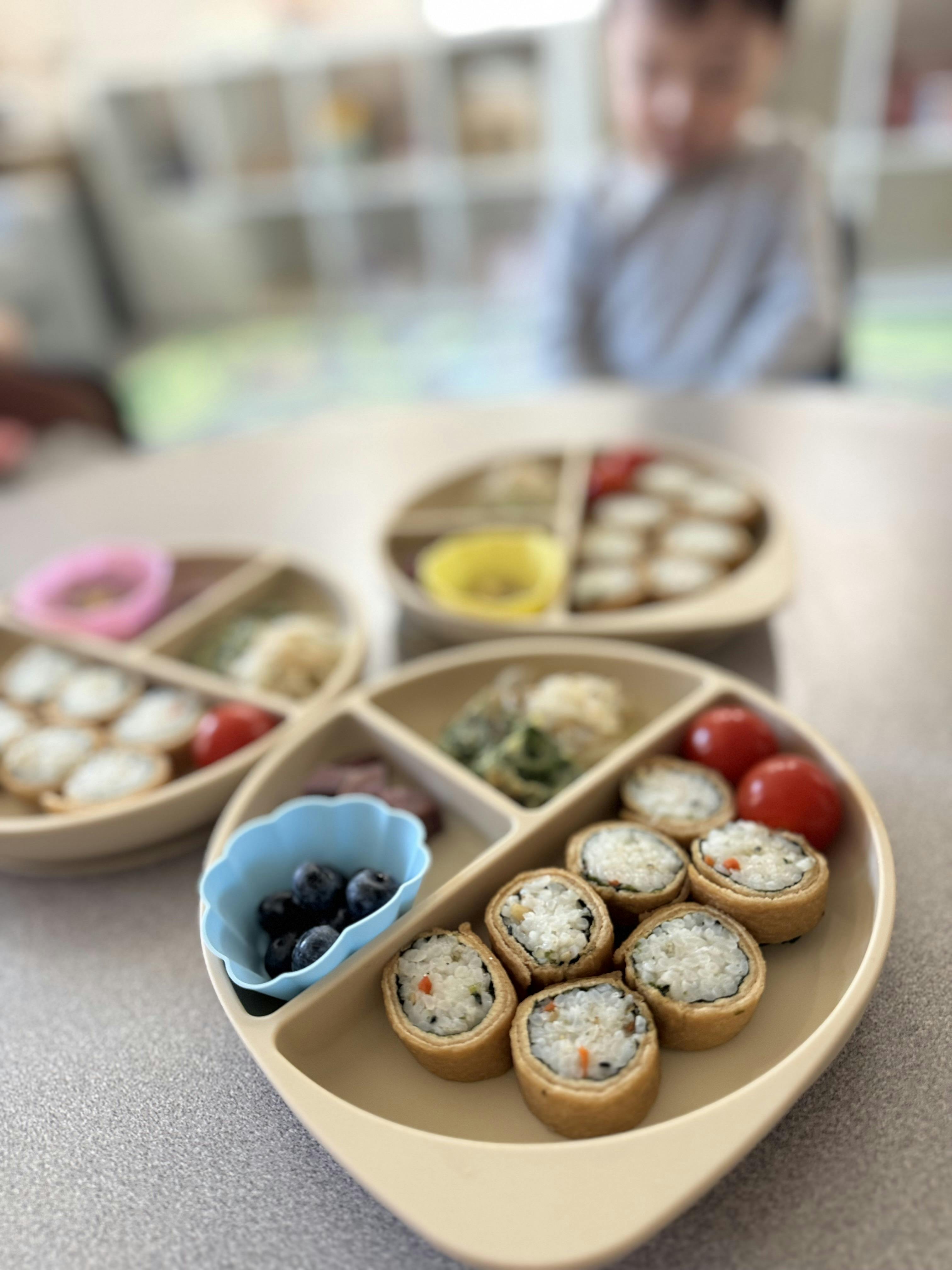 Close-up of three plates of food with a child in the background