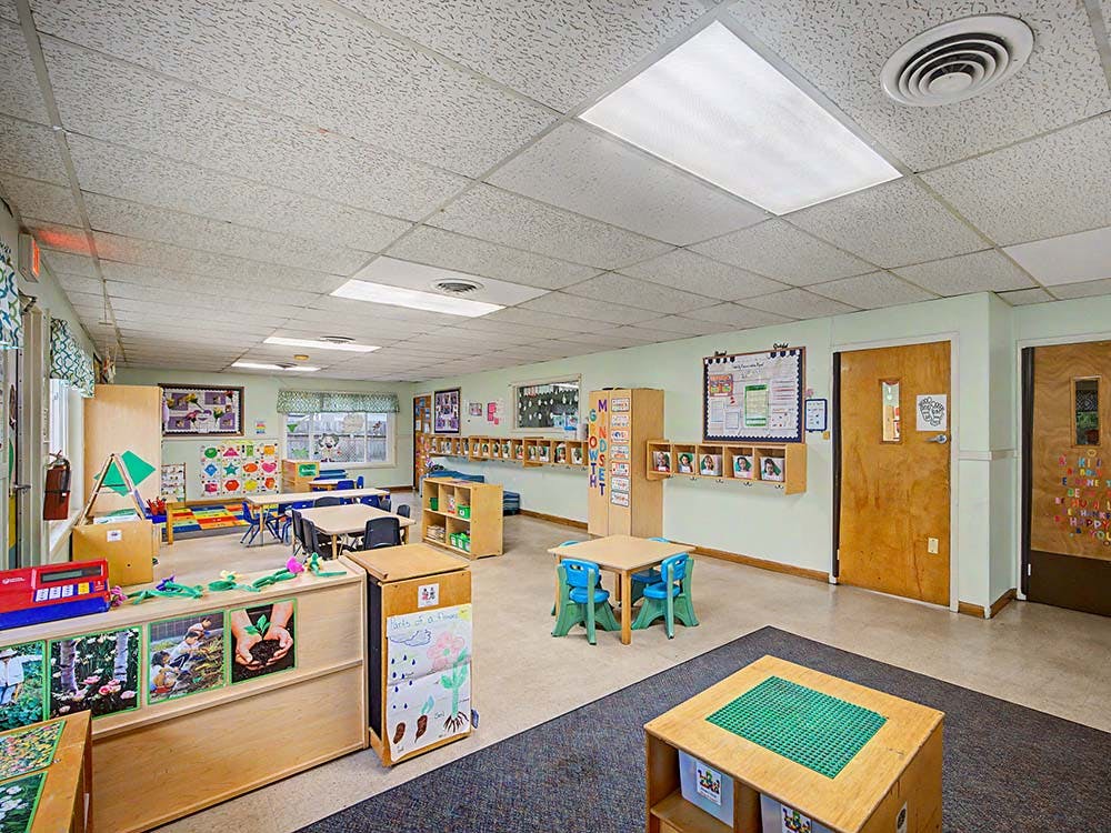 Empty colorful children's classroom with small tables and chairs
