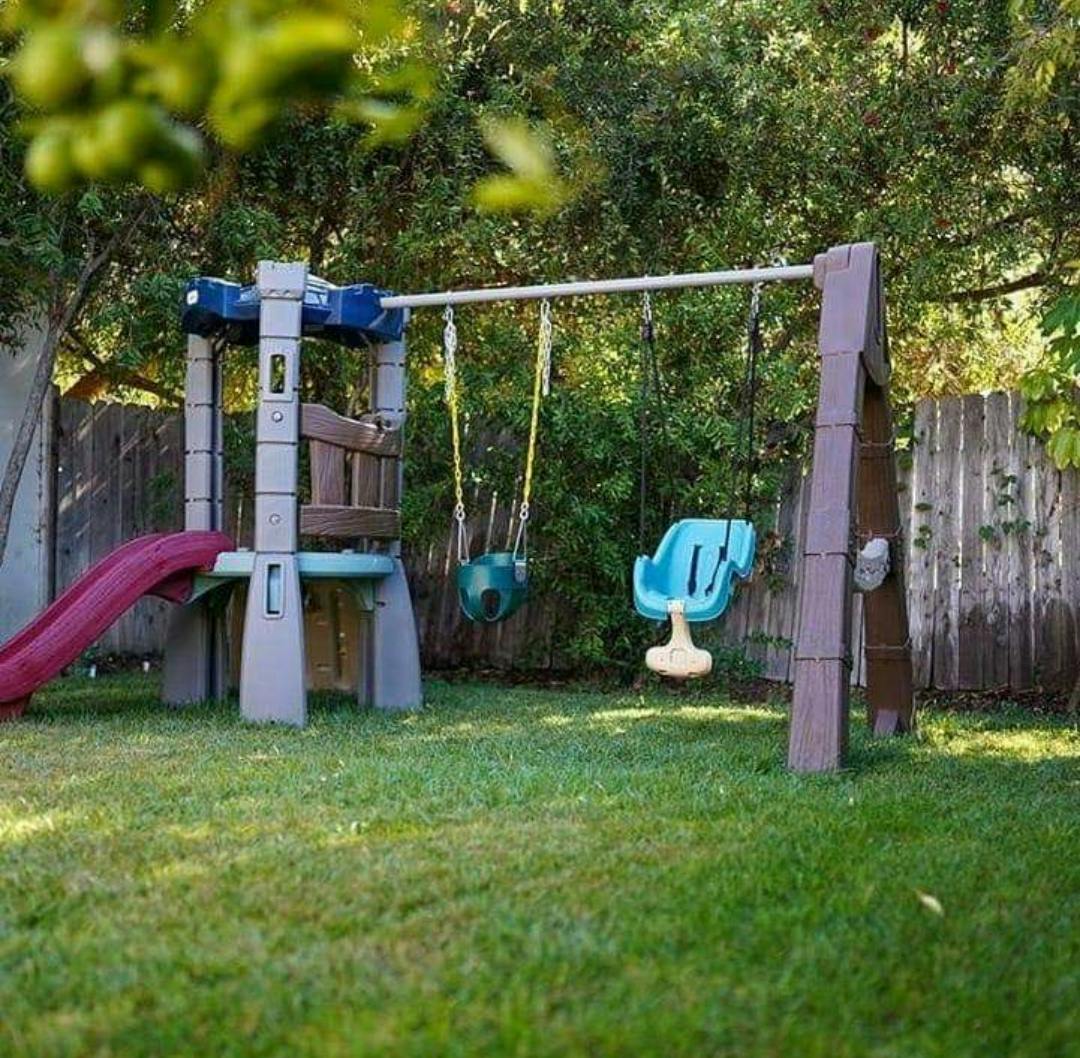 Playground with a slide and swings in a grassy yard