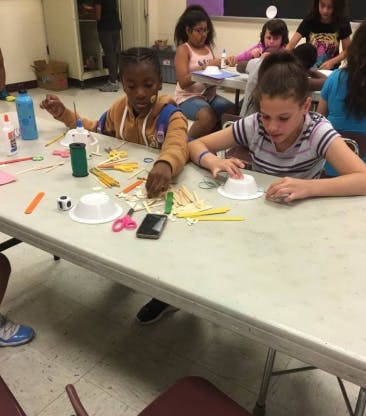 Two children at a table with craft supplies