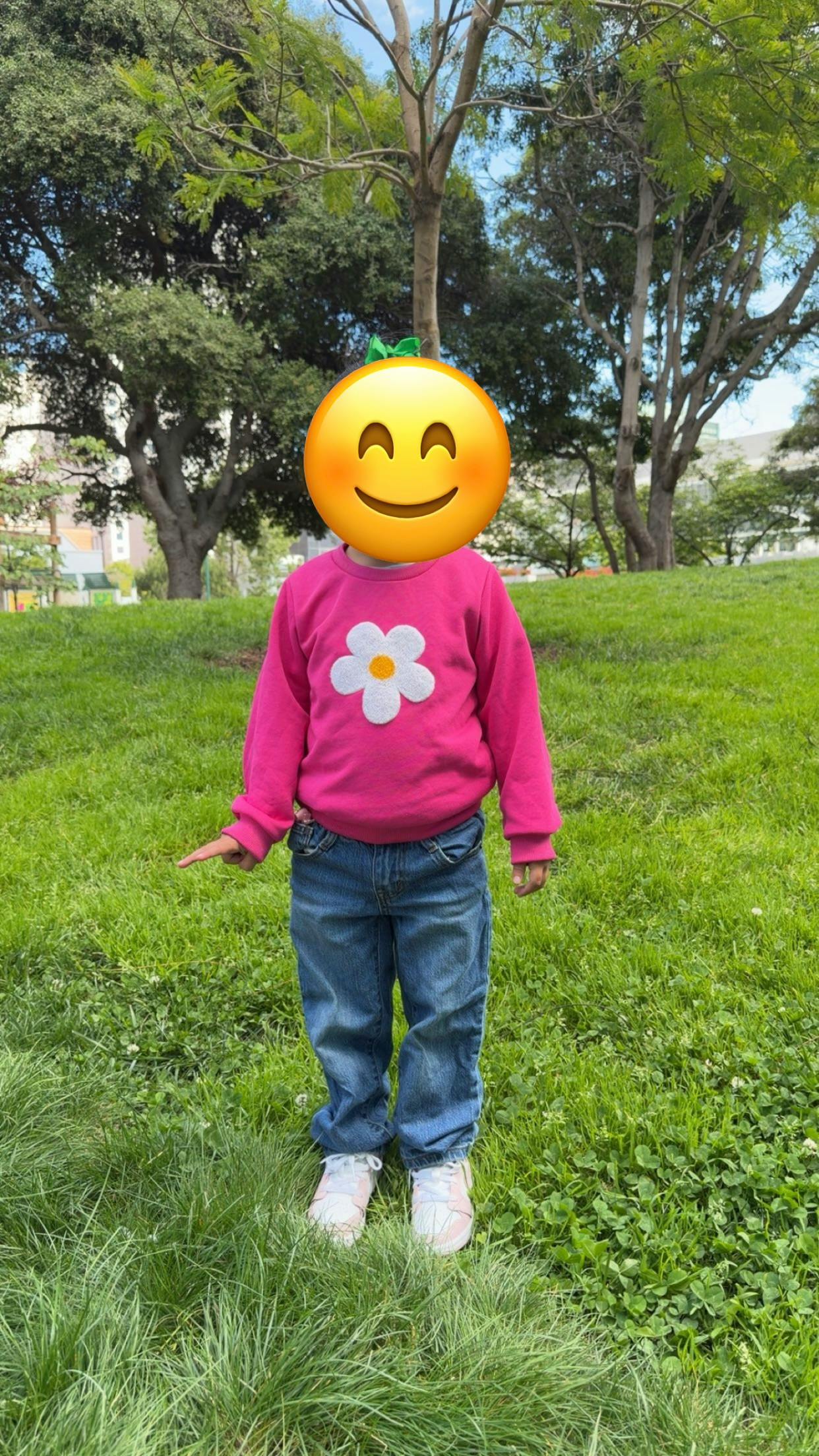 Child standing on grass in a park