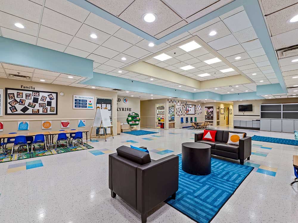 Lounge area in a school hallway with a couch, table, and chairs