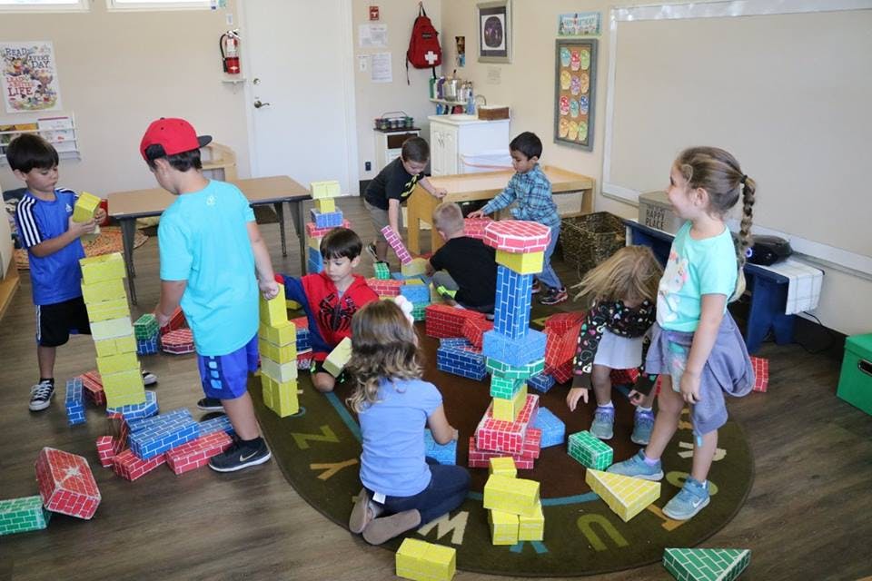 Children playing with large building blocks in a classroom