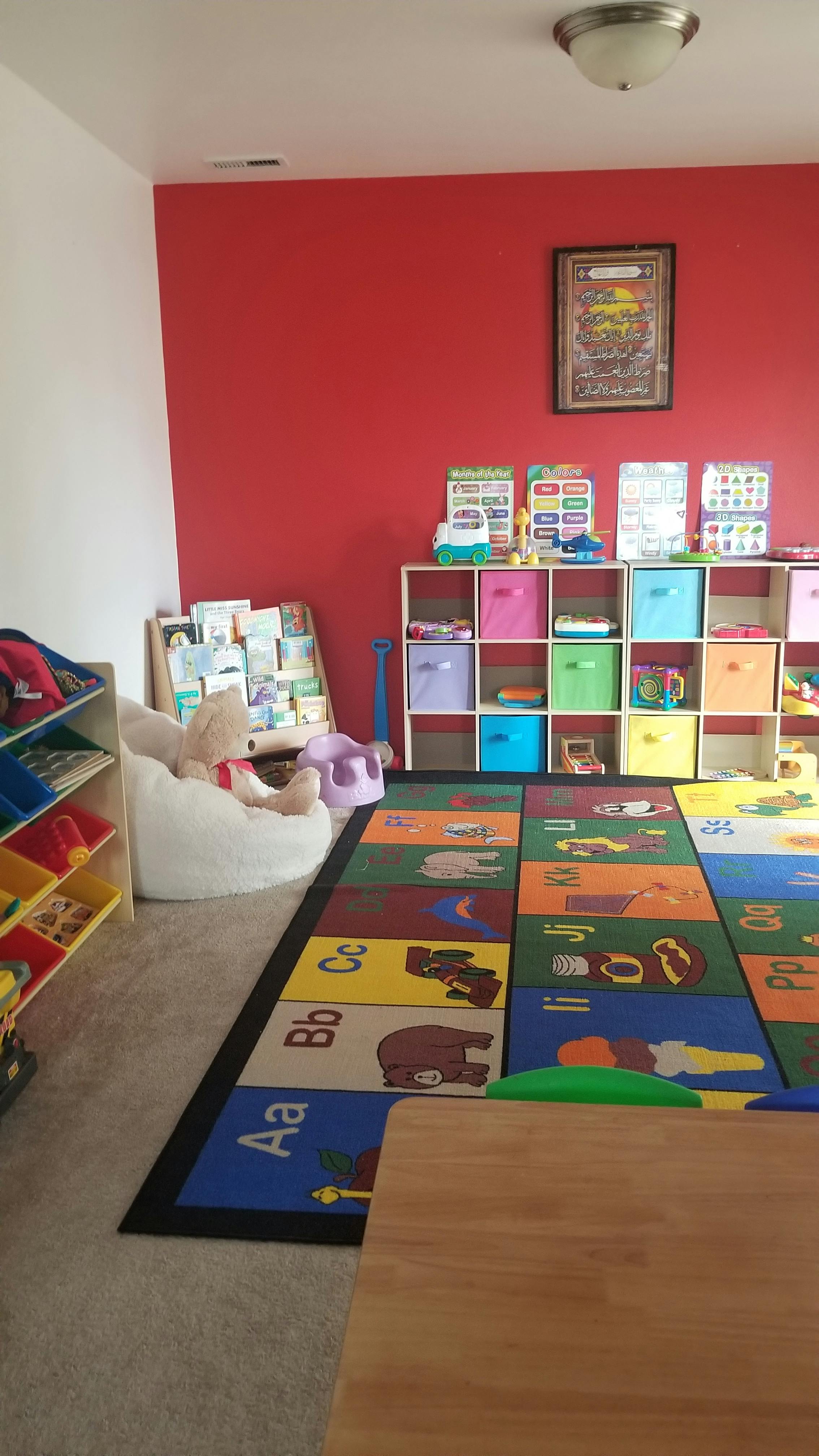 Playroom with alphabet rug, storage shelves, and beanbag chair