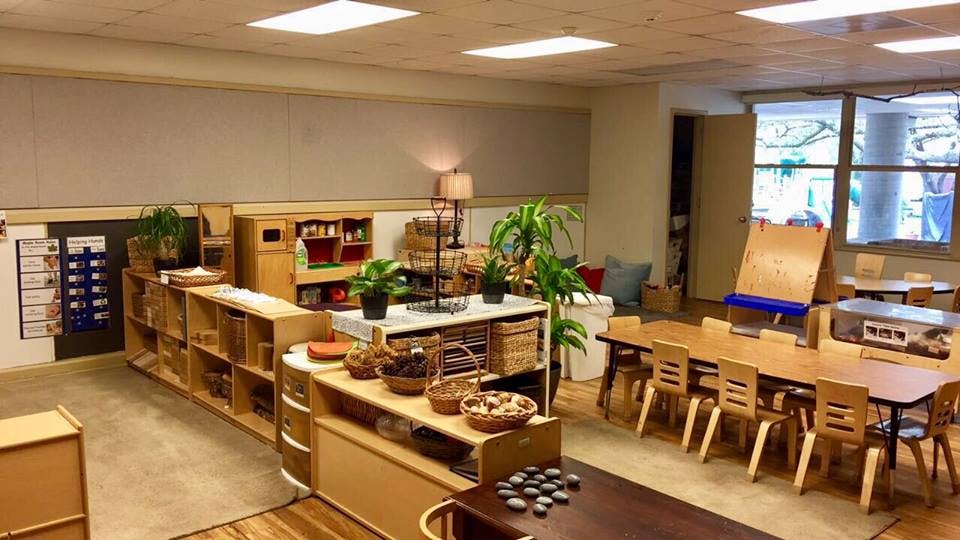 Classroom with tables, chairs, and shelves with learning materials