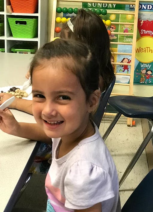 Child sitting at a table in a classroom