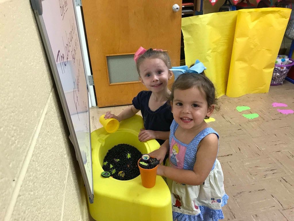 Two children playing with a yellow toy