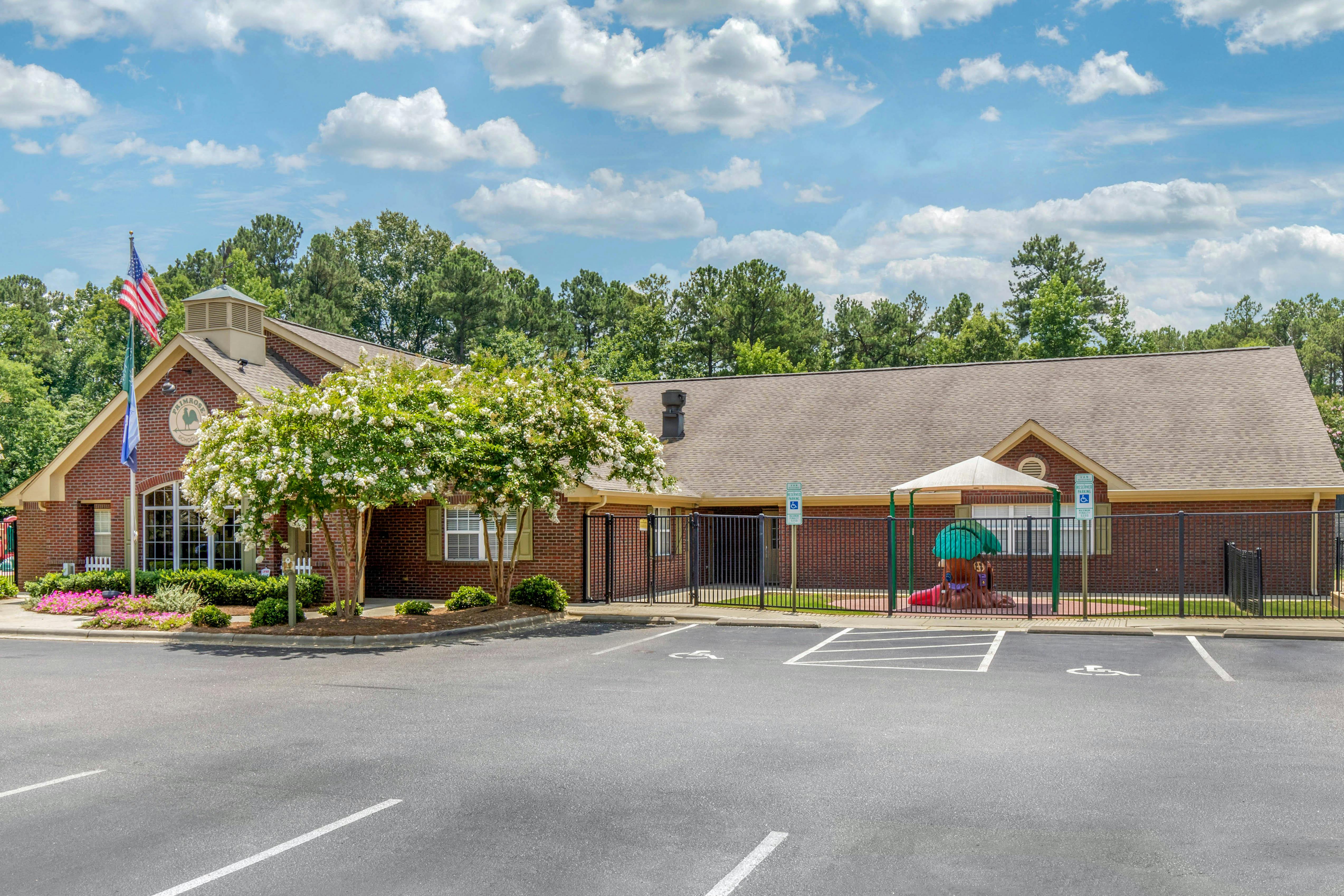 Brick building with a parking lot and a fenced playground